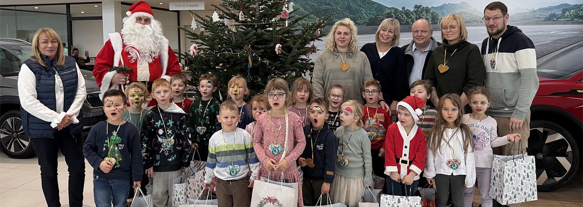 Gruppenbild der Kita-Gruppe vor dem geschm&uuml;ckten Weihnachtsbaum im Skoda Autohaus Nordhausen