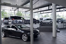 Innenraum eines Mercedes-Benz-Autohauses in Heiligenstadt. Im Vordergrund sieht man ein elegantes schwarzes Fahrzeug, im Hintergrund weitere ausgestellte Modelle auf verschiedenen Ebenen. Der Showroom wirkt modern, hell und großzügig, mit großen Fensterfronten und viel Tageslicht. (Foto: Fischer/Autohaus Peter)