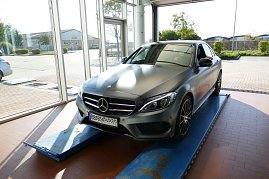 „Werkstattbereich im Mercedes-Benz Autohaus Bernburg, ein grauer Mercedes-Benz steht auf einer Hebebühne vor großen Glasfenstern, im Hintergrund Außenbereich sichtbar. (Foto: Fischer/Autohaus Peter)