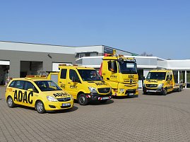 Vier gelbe ADAC-Servicefahrzeuge (ein PKW, zwei Transporter und ein LKW) stehen vor dem Gebäude des ADAC Mobilitätspartners Peter in Nordhausen auf einem gepflasterten Hof. Die Fahrzeuge sind mit ADAC- und Peter-Logos beschriftet. Im Hintergrund das moderne Werkstatt- und Bürogebäude. (Foto: Autohaus Peter GmbH)
