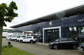 Peugeot Autohaus in Göttingen mit großer Glasfassade und prominentem Löwen-Logo, mehrere weiße und ein schwarzes Peugeot-Fahrzeug vor dem Gebäude geparkt. (Foto: Fischer/Autohaus Peter)