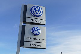 Hoher VW-Servicepylon mit zwei blauen Volkswagen-Logos. Oben steht Service, unten Nutzfahrzeuge Service. Der Himmel ist klar und blau mit leichten Wolken und Kondensstreifen. (Foto: Fischer/Autohaus Peter)