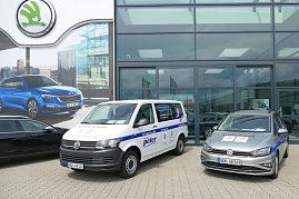 Zwei Volkswagen Servicefahrzeuge mit der Aufschrift Wir halten Sie mobil stehen vor dem modernen Glasgebäude der Autowelt Peter GmbH. Links ein VW Transporter, rechts ein silberner VW Golf. Im Hintergrund ein großes koda-Werbeschild mit einem blauen Auto. (Foto: Fischer/Autohaus Peter)