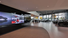 Moderner Ausstellungsraum eines Mercedes-Benz Autohauses mit großem LED-Bildschirm, vielen Neuwagen in heller, verglaster Halle. (Foto: Steve Dornhofer/Autohaus Peter )