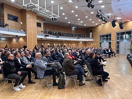 Weitwinkelaufnahme des Saals mit vielen Gästen, die aufmerksam nach vorn zur Bühne schauen. (Foto: Autohaus Peter )