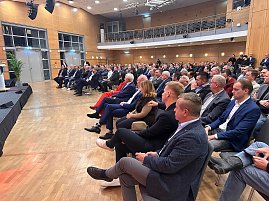 Publikum im Saal hört aufmerksam einer Rednerin auf der Bühne zu. Viele Männer im Anzug, einzelne Frauen im Publikum. (Foto: Autohaus Peter )