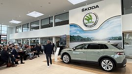 Der neu vorgestellte koda Elroq steht in voller Größe im Ausstellungsraum. Im Hintergrund sitzen Gäste und hören dem Vortragenden zu. Über dem Auto hängt das große koda-Logo. (Foto: Autohaus Peter)