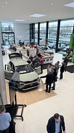 Blick von oben auf den neuen koda Elroq im Showroom. Gäste stehen um das Fahrzeug, schauen hinein oder diskutieren. Links im Bild ein Präsentationsbildschirm. (Foto: Autohaus Peter)