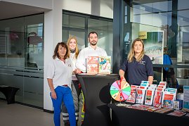 Vier Personen stehen hinter einem Infostand im koda Autohaus. Auf dem Tisch liegen Broschüren und ein Glücksrad. Die Personen tragen Kleidung mit Logos des Deutschen Roten Kreuzes. (Foto: Autohaus Peter)