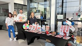 Vier Personen stehen hinter einem Infostand im koda Autohaus. Auf dem Tisch liegen Broschüren und ein Glücksrad. Die Personen tragen Kleidung mit Logos des Deutschen Roten Kreuzes. (Foto: Autohaus Peter)