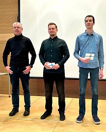 Robert Rausch und Florian Kahl stehen neben ihrem Berufsschullehrer. Beide halten einen Geschenkgutschein, während sie für die Auszeichnung posieren. (Foto: Autohaus Peter Gruppe)