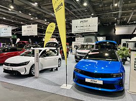 Vorne ein weißer Opel Corsa und daneben ein blauer Opel Astra, beide mit geöffneten Türen und Kofferräumen auf der Messe präsentiert. (Foto: Autohaus Peter Gruppe)