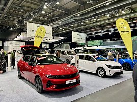 Ein roter Opel Astra und ein weißer Opel Grandland Hybrid stehen nebeneinander auf der Ausstellungsfläche, mit Opel-Fahnen und Peter-Bannern im Hintergrund. (Foto: Autohaus Peter Gruppe)