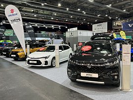 Ein schwarzer und ein weißer Suzuki stehen nebeneinander. Im Hintergrund weitere Autos verschiedener Marken unter Peter-Bannern. (Foto: Autohaus Peter Gruppe)