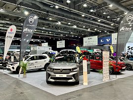 Ein grauer Citroën SUV und ein weißer Citroën C3 sind ausgestellt, mit Citroën-Fahnen und weiteren Markenständen im Hintergrund. (Foto: Autohaus Peter Gruppe)