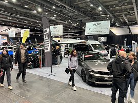 Blick auf mehrere Opel-Fahrzeuge, darunter ein grauer Opel mit offener Motorhaube und ein Wohnmobil. Besucher laufen über die Messefläche. (Foto: Autohaus Peter Gruppe)