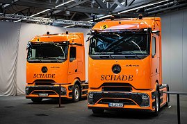 Zwei orangefarbene Mercedes-Benz eActros 600 Sattelzugmaschinen mit Schade-Logo in einer Halle. (Foto: Daimler Truck AG)