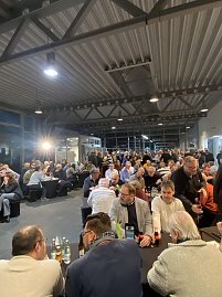 Großer Saal im Autohaus, viele Menschen sitzen dicht gedrängt an langen Tischen und hören der CDU-Veranstaltung zu. (Foto: Autohaus Peter)