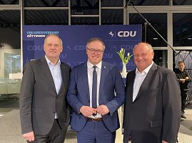 Drei Männer in Anzügen (Fritz Güntzler, Mario Voigt und Helmut Peter) stehen vor einem CDU-Banner und lächeln in die Kamera. (Foto: Autohaus Peter)