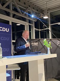 Helmut Peter spricht am Pult mit Mikrofon. Hinter ihm CDU-Banner und Autohaus-Logo „Peter“. (Foto: autohaus peter)