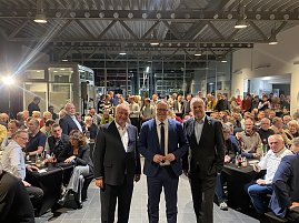 Blick in den Saal: Fritz Güntzler, Mario Voigt und Helmut Peter stehen vorne, hinter ihnen viele Gäste, die den CDU-Wahlkampfauftritt verfolgen. (Foto: Autohaus Peter)