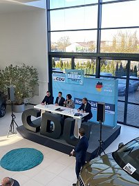 Blick leicht von oben auf Podiumsdiskussion mit vier Teilnehmenden, darunter Colette Boos-John. Vor der Bühne große schwarze CDU-Buchstaben, im Hintergrund ein Skoda-Auto. (Foto: Autohaus Peter)