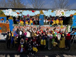 Große Gruppe verkleideter Menschen posiert vor und auf einem bunt gestalteten Karnevalswagen mit Märchenmotiven, viele halten bunte Luftballons. (Foto: Autohaus Peter GmbH)
