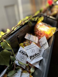 Detailaufnahme von Bonbons mit der Aufschrift Helau, Alaaf & Ahoi! und dem Autohaus-Peter-Logo, dekoriert mit Efeuranken, im Hintergrund weitere Süßigkeiten. (Foto: Autohaus Peter GmbH)