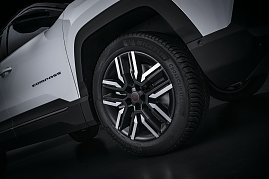 Nahaufnahme des Vorderrads eines weißen Jeep Compass mit schwarzer und silberner Leichtmetallfelge, Michelin CrossClimate-Reifen und sichtbarem „Compass“-Schriftzug an der Seite. (Foto: FCA Germany GmbH)