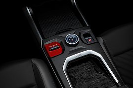 Nahaufnahme der Mittelkonsole mit Wählrad für Fahrstufen (R, N, D, P), rotem „Select Terrain“-Schalter, elektronischer Parkbremse und Ablagefläche mit Jeep-Logo. (Foto: FCA Germany GmbH)