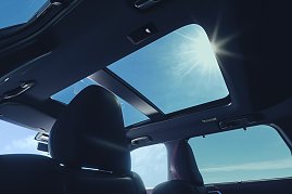 Panoramadach: Blick aus dem Innenraum des Mitsubishi Outlander auf das geöffnete Panoramadach mit Sonnenlicht und blauem Himmel. (Foto: Mitsubishi Motors)