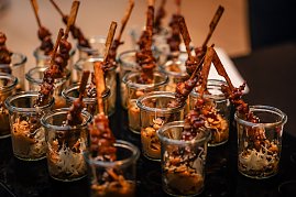 Mehrere kleine Gläser gefüllt mit asiatisch anmutenden Snacks, darin marinierte Fleischspieße mit Sesam und Beilage. (Foto: Eric Freytag)