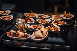 Kleine weiße Schälchen und Gläser mit Fingerfood, darunter Fleischspieße, Frühlingsrollen und Nudeln, appetitlich angerichtet. (Foto: Eric Freytag)