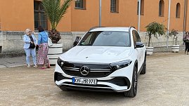 „Weißer Mercedes EQB parkt vor dem historischen Achteckhaus Sondershausen, während sich Gäste des Konzertabends unterhalten. (Foto: Autohaus Peter)