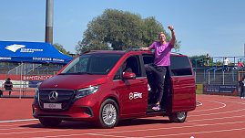 Stabhochspringer Piotr Lisek steigt aus einem roten, vollelektrischen Mercedes EQV im Stadion aus. (Foto: Autohaus Peter)
