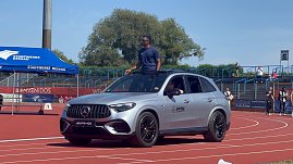 Ein silberner Mercedes-Benz SUV des Autohauses Peter fährt auf der roten Laufbahn beim Leichtathletik-Meeting Anhalt 2025. Ein Sportler steht aus dem geöffneten Schiebedach, im Hintergrund sind Zuschauertribünen und ein blaues Stadtwerke-Dessau-Zelt zu sehen. (Foto: Autohaus Peter )