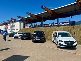 Mehrere Mercedes-Benz Fahrzeuge, präsentiert vom Autohaus Peter, stehen aufgereiht am Rand des Stadions beim Anhalt 2025 Leichtathletik-Meeting. Unter den ausgestellten Autos sind ein weißer eCitan, ein schwarzer EQV und weitere Mercedes-Modelle zu sehen. Im Hintergrund befinden sich Zuschauertribünen, ein Banner mit der Aufschrift european-athletics.com und einige Besucher auf dem Gelände. (Foto: Autohaus Peter )