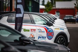 Nahaufnahme einer Reihe weißer Opel-SUVs mit schwarzem Dach, die nebeneinander auf einem Parkplatz stehen. Auf der Fahrertür des vordersten Fahrzeugs sind zahlreiche Logos zu sehen, darunter „THC Thüringer Handball Club“, „Autohaus Peter“, „TMP Fenster + Türen“, „Joma“, „Universal Bau“ und weitere. (Foto: Christian_Heilwagen_Sports)