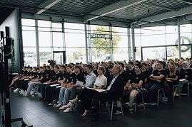 Reihe neuer Auszubildender der Autohaus-Peter-Gruppe sitzt in der Firmenzentrale in Nordhausen. Alle tragen schwarze T-Shirts mit Firmenlogo und hören der Auftaktveranstaltung aufmerksam zu. (Foto: Autohaus Peter)
