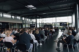 Blick von hinten in die Veranstaltungshalle: Zahlreiche Auszubildende und ihre Eltern sitzen in Reihen und verfolgen die Begrüßung der Autohaus-Peter-Gruppe. (Foto: Autohaus Peter)