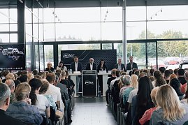 Blick auf das Podium mit der Geschäftsführung und Ausbildungsleitung der Autohaus-Peter-Gruppe. Dahinter große Fensterfront, davor sitzen die neuen Auszubildenden und Gäste. (Foto: Autohaus Peter)
