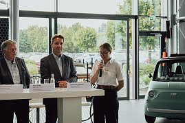 Lilly Hecker steht am Rednerpult mit einem Mikrofon und spricht zu den neuen Auszubildenden. Neben ihr stehen Mitglieder der Geschäftsführung der Autohaus-Peter-Gruppe. (Foto: Autohaus Peter)