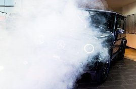 Eine schwarze Mercedes G-Klasse wird in Szene gesetzt. Dichter weißer Nebel und Scheinwerferlicht verdecken teilweise das Auto. (Foto: Buchardt | Autohaus Peter )