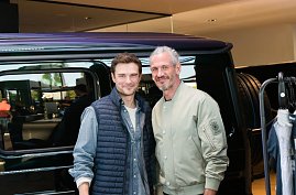 Zwei Männermodels stehen nebeneinander vor einem schwarzen Mercedes. Beide lächeln in die Kamera, einer trägt eine helle Bomberjacke, der andere eine dunkle Weste. (Foto: Buchardt | Autohaus Peter )