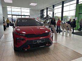 Ein roter koda Elroq steht im Ausstellungsraum des Autohauses Autowelt Peter. Im Hintergrund stehen und unterhalten sich mehrere Besucher, daneben befinden sich Infostände und ein Bereich mit Sitzgelegenheiten. (Foto: Autohaus Peter)