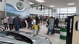 Besucherinnen und Besucher im Autohaus Autowelt Peter während der Jubiläumsfeier zu 130 Jahren koda. Im Ausstellungsraum stehen Fahrzeuge, Kranzdekorationen und ein Tisch mit Sektgläsern. (Foto: Autohaus Peter)
