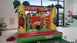 Kinder spielen auf einer bunten Hüpfburg mit Tier- und Insektenmotiven im Autohaus Autowelt Peter. Die Hüpfburg ist Teil des Familienprogramms zur Feier von 130 Jahren koda. (Foto: Autohaus Peter)