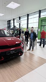 Ein roter koda Elroq steht im Ausstellungsraum. Mehrere Besucher stehen daneben und informieren sich an den Infostelen. (Foto: Autohaus Peter)