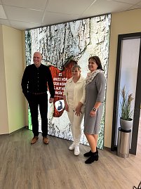 Bürgermeister, Landrätin und Ärztin stehen vor beleuchtetem XXL Wandbild und lächeln in die Kamera (Foto: Autohaus Peter)