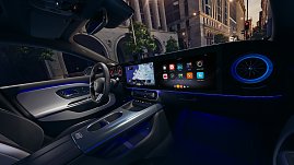 Das Bild zeigt einen wei&szlig;en Mercedes-Benz CLA Shooting Brake, der auf einer breiten, nahezu leeren Stadtstra&szlig;e f&auml;hrt. Moderne Geb&auml;ude umgeben die Szene, das Licht wirkt weich und fr&uuml;hmorgendlich. Der Wagen ist seitlich zu sehen und vermittelt Dynamik sowie Eleganz.